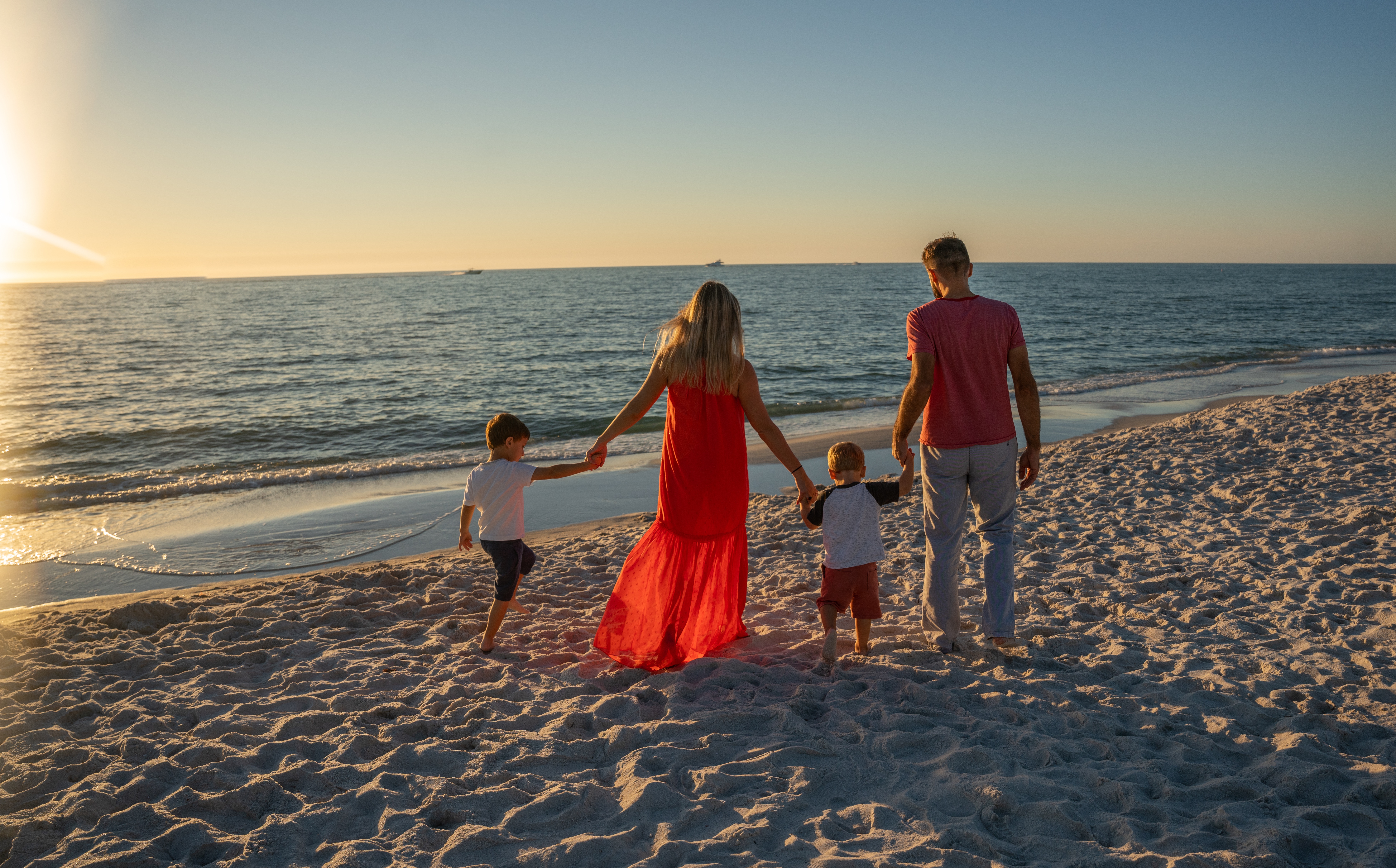 Familie loopt over strand