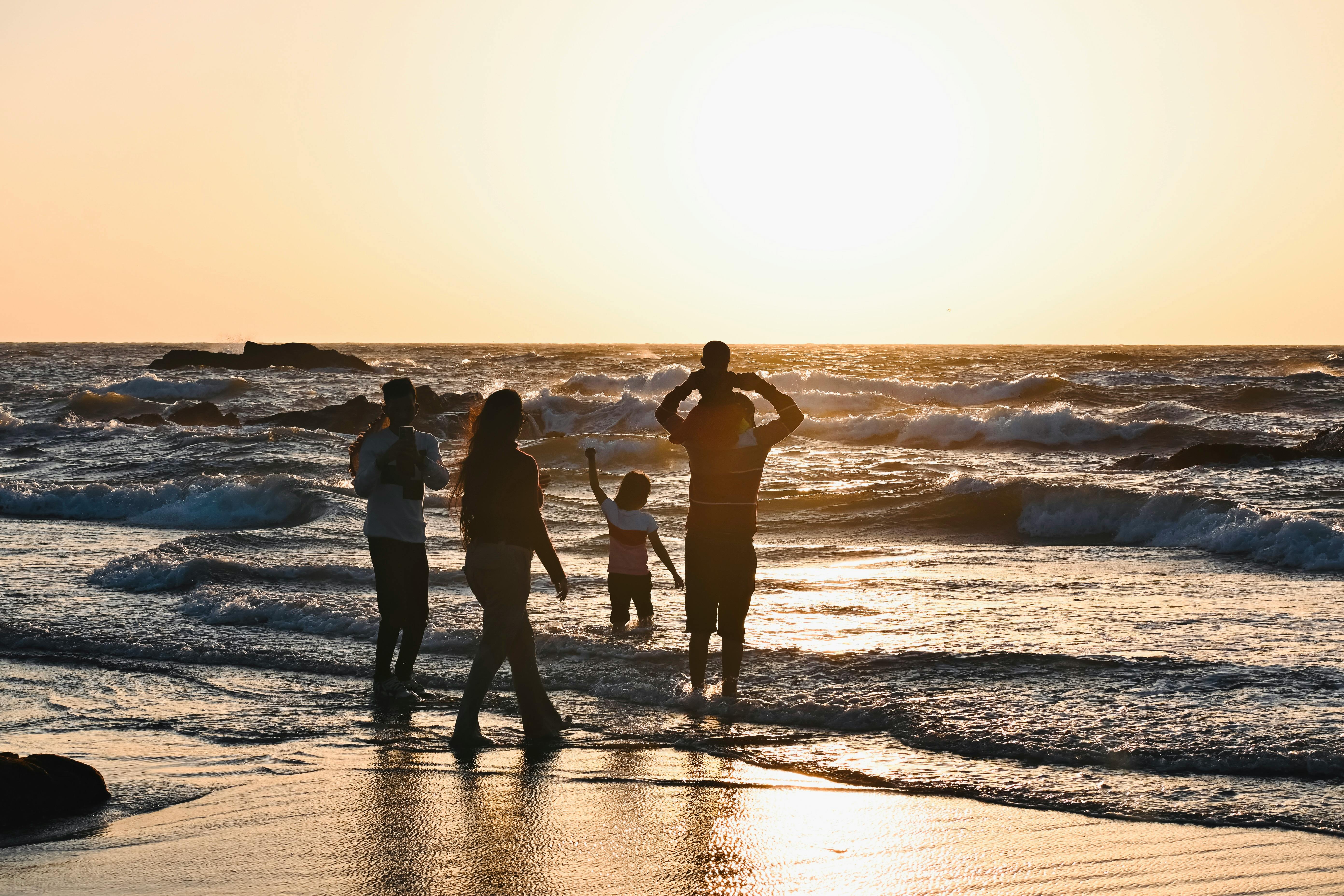 Familie op het strand tijdens zonsondergang