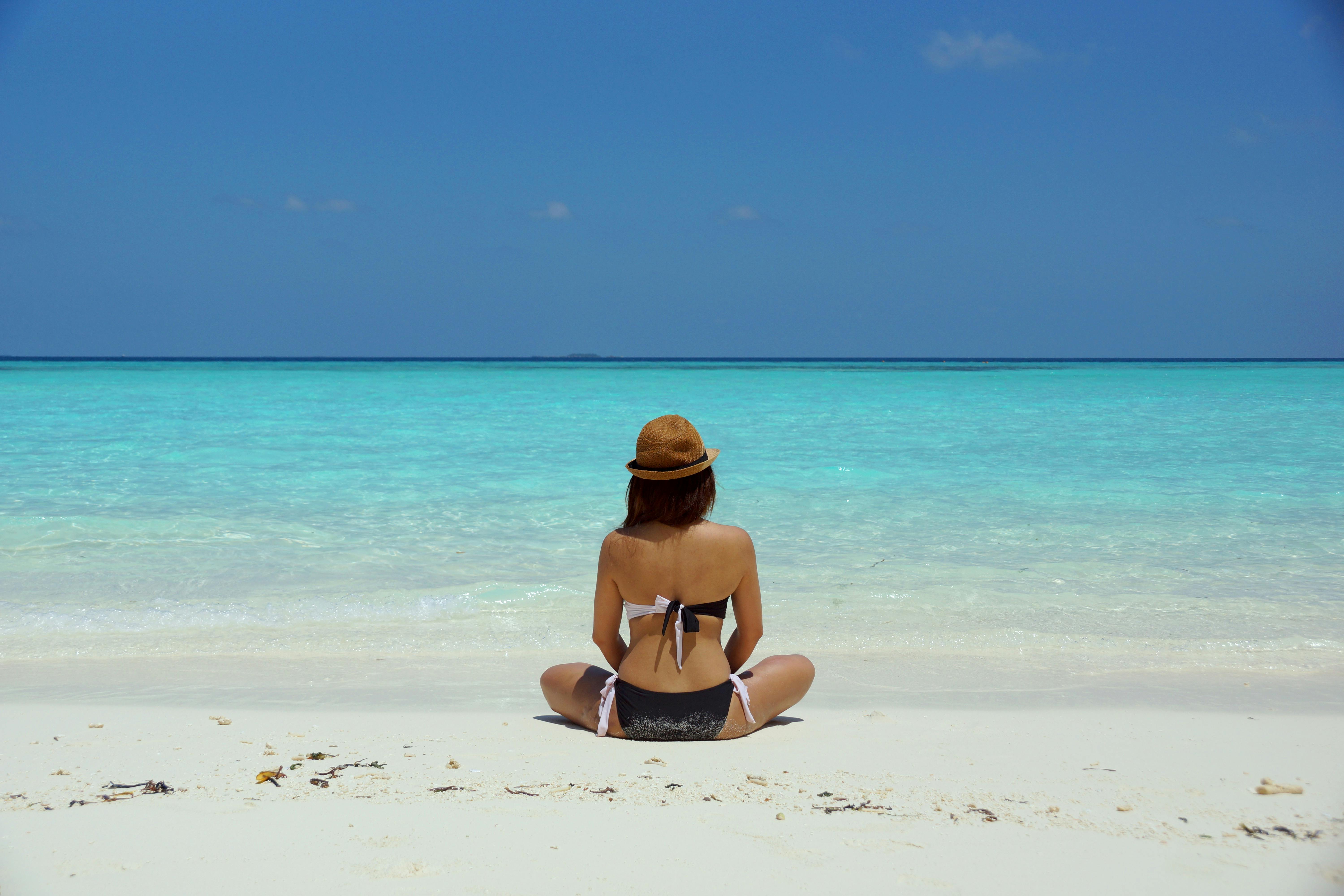 Vrouw zittend op tropisch strand